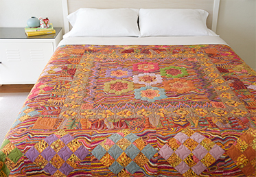 Kaffe Fassett and Liza Lucy  work together to create a masterful medallion quilt in rich, warm tones. The quilt begins with a stunning medallion center that is comprised of English paper-pieced hexagon rings and hand-appliqued fussy-cut fabrics. 