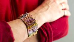 Liz Smith teaches a freeform approach to looming, showing you how to set up a loom and basic weaving techniques with her “over, under, over under” mantra. You design as you go, resulting in a modern asymmetrical, textured cuff. 