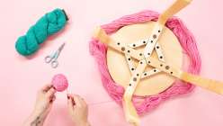 A pair of hands using the legs of a stool to wind a ball of yarn from Twinkie Chan's How to Wind a Center-Pull Ball of Yarn class on Creativebug