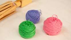 Three balls of yarn made in Twinkie Chan's How to Wind a Center-Pull Ball of Yarn class on Creativebug