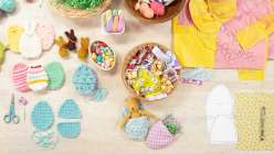 a table top view of Easter crafting items and supplies including re-useable easter eggs, candy and paper