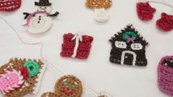 A crocheted snowman, a crocheted house, and a crocheted present made by Twinkie Chan in her Holiday Crochet Applique class on Creativebug