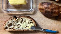 A piece of sourdough bread spread with butter made in the Make Homemade Butter class on Creativebug