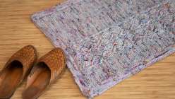 A colorful hand-knit mat made by Liza Laird in her Yoga of Yarn: Brioche Knit Meditation Mat class on Creativebug