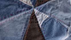 A close-up image of an Upcycled Denim Spinning Wheel Quilt made by Sandra Chandler in her class on Creativebug.
