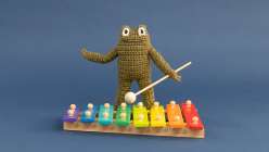 A crocheted frog toy made by Twinkie Chan in her Crochet a Posable Frog class on Creativebug